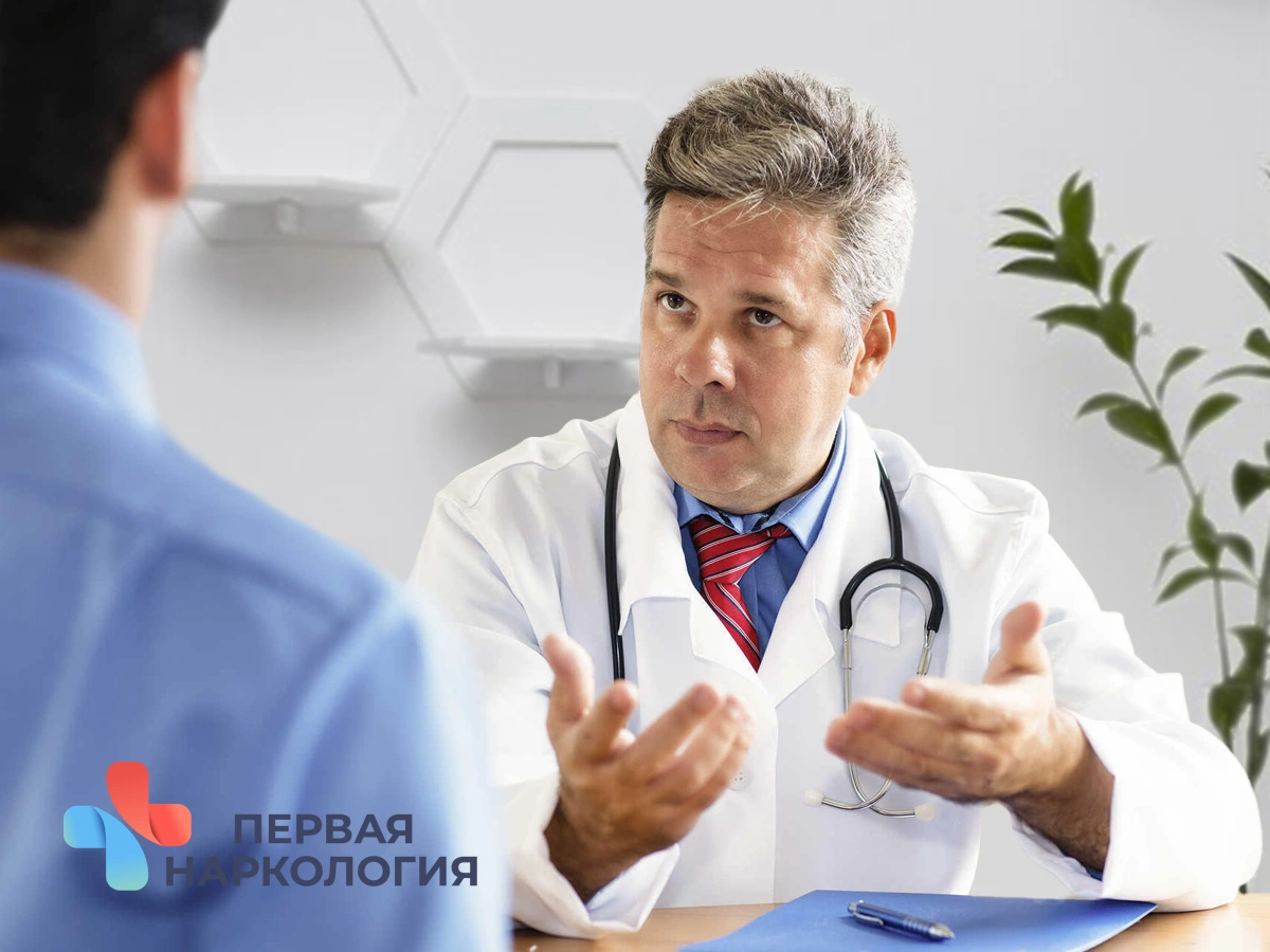 Врач сидит за столом перед пациентом